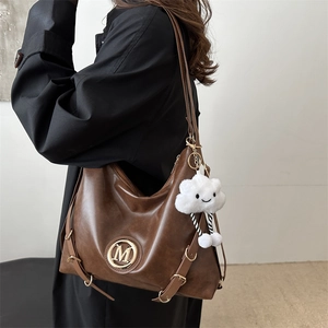 Brown vintage faux leather tote bag with metal M ring logo and plush cloud charm decor
