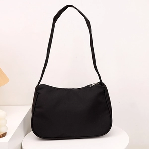 Minimalist black crescent shoulder bag in sleek nylon with metallic silver zipper closure