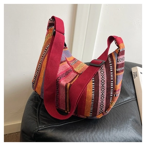 Close-up of ethnic style tote bag with colorful striped woven texture and red strap