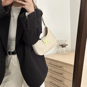 Minimalist off-white leather hobo bag with a gold metal clasp for modern women