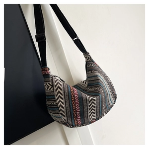 Detailed texture of multi-colored geometric woven hobo bag with black adjustable strap