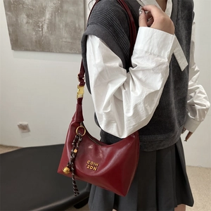 Sac croissant bordeaux chic avec logo doré et breloque tressée élégante pour femme