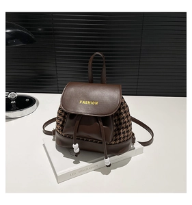 Detail of vintage brown leather mini backpack with houndstooth side panels and drawstring