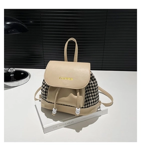 Close-up of beige leather and houndstooth backpack with gold-tone fashion lettering