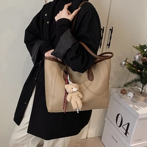 Sac fourre-tout minimaliste en cuir marron clair avec poignées sombres et ourson