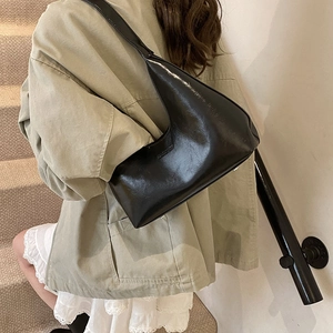 Minimalist black crescent hobo bag in glossy leather, perfect for daily commuting