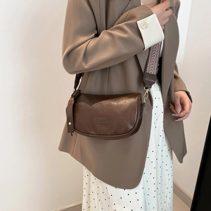 Retro brown half-moon crossbody bag with vintage leather texture and woven shoulder strap