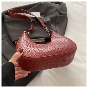 Détail du sac hobo bordeaux en cuir tressé avec boucle métallique dorée élégante