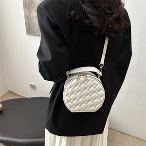 Modern white quilted round crossbody bag with gold hardware and top handle for women