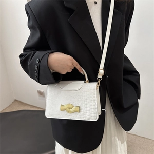White croc-effect leather handbag with gold wavy metal clasp and adjustable shoulder strap
