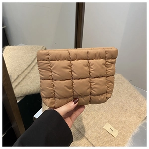 Close-up of caramel checkered quilted clutch with smooth glossy nylon texture and fluffy design