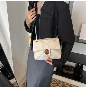 Dettaglio borsa a tracolla trapuntata beige con chiusura dorata vintage e tracolla a catena
