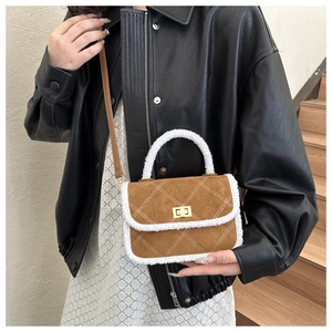 Detail of brown suede crossbody bag featuring white faux fur trim and gold metal lock