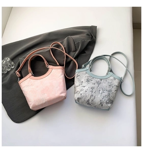 Vue de dessus de sacs seau en soie à broderie florale rose et bleue avec bretelles