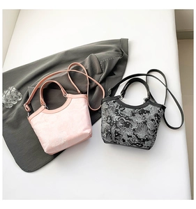Détail du sac seau en soie brodée avec motifs traditionnels et accessoires en métal argenté