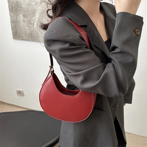 Minimalist red crescent shoulder bag in sleek faux leather for trendy casual commuting
