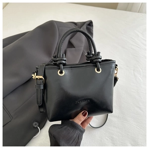 Macro shot of black bucket bag with FASHION logo and golden hardware details