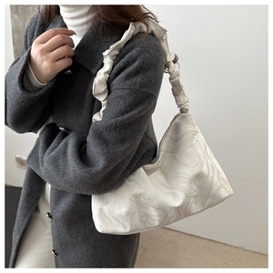 Detail of ruffled shoulder strap on marbled cream white leather hobo bag for women
