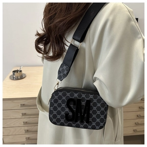 Detail shot of vintage pattern crossbody bag with wide shoulder strap and SM logo