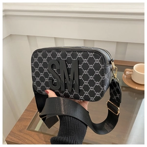 Detail of cross-body camera bag with black monogram canvas and wide canvas strap