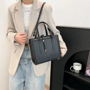 Minimalist black matte leather rectangular handbag with dual top handles and long strap