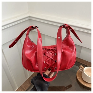Close-up of red PU leather handbag with corset-style lace-up ribbons and silver eyelets