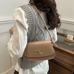 Chic apricot leather underarm bag with golden bow buckle and knotted shoulder strap