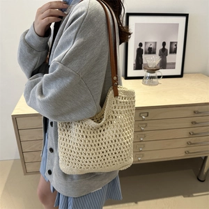 Large cream woven tote bag with brown leather shoulder straps for casual beach vacation