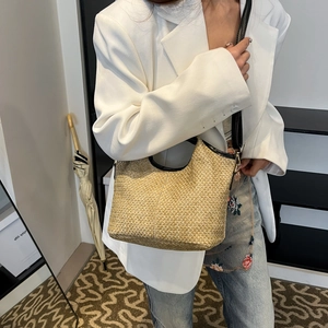 Chic woven straw hobo bucket bag with black leather straps for summer vacations