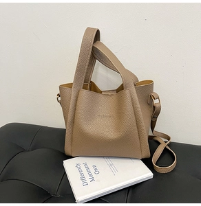 Detailed close-up of litchi texture on a vintage brown bucket bag with FASHION logo