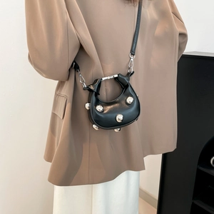 Fashionable black crescent crossbody bag with large silver metal sphere decorations