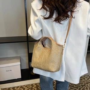 Handcrafted straw bucket bag with thin strap for crossbody and top handle use