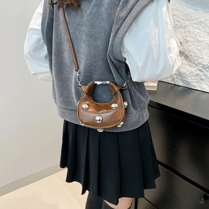 Brown leather crescent bag with silver rivets and thin shoulder strap for women