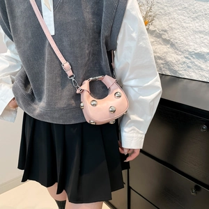 Pink crescent crossbody bag with silver metallic ball studs and adjustable strap