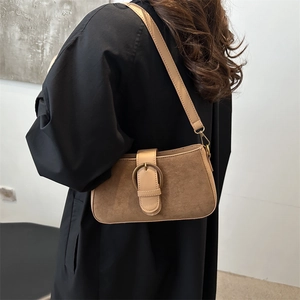 Retro brown suede baguette shoulder bag with large vintage bronze buckle on a model