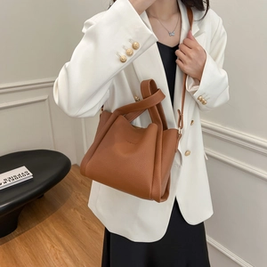 Retro warm brown lychee leather bucket bag with gold hardware and thin crossbody strap