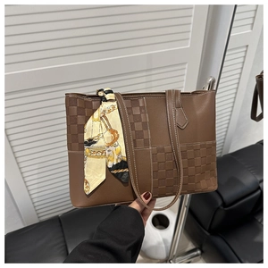 Detailed view of brown leather tote with checkered pattern and decorative silk scarf