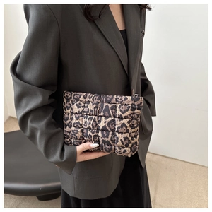 Detail of leopard print quilted clutch bag with metallic zipper and soft padded texture