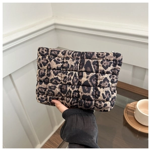 Detailed macro view of quilted leopard print pouch with a puff fabric texture and zipper
