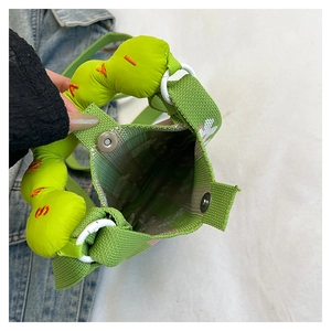 Detail of green knit bag showing checkered lining and magnetic silver metal clasp