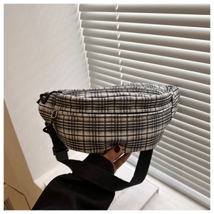 Gros plan d'un sac de poitrine à carreaux noir et blanc élégant avec un design décontracté.