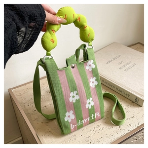 Detail of green and pink knitted crossbody bag with soft padded handle and b-daygift text