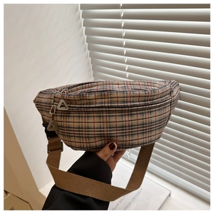 Gros plan d'un sac de poitrine à carreaux pour femmes avec sangle marron réglable