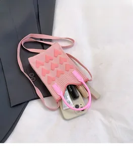Detail view of the pink knit mobile bag featuring 3D heart patterns and soft texture