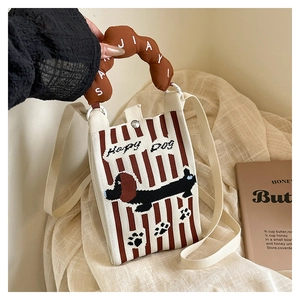Close-up of knitted mini bag with Happy Dog pattern and plush handle texture details