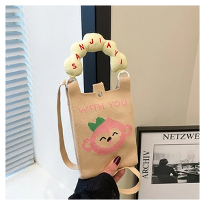 Close-up of beige knitted mini bag with pink cartoon design and yellow cloud-shaped handle