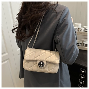 Quilted beige shoulder bag with chain strap shown on model for a trendy commuter style