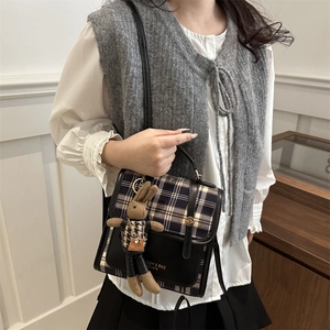 Sac à dos vintage à carreaux avec breloque lapin mignon porté dans un style décontracté