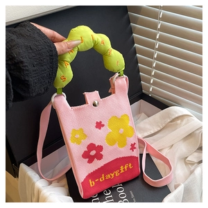 Close-up of pink knit mini phone bag with flower patterns and 'b-day gift' text