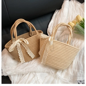 Détail des sacs cabas tissés avec des accents délicats de nœuds en dentelle blanche